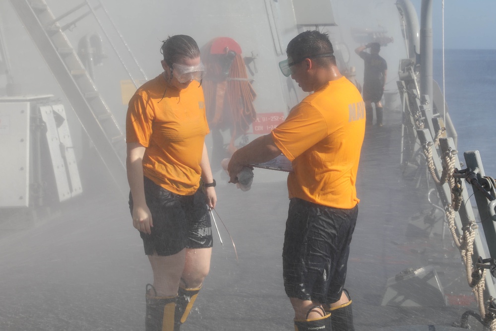 Sailors aboard the USS Rafael Peralta (DDG 115) conduct a countermeasure wash down in the East China Sea