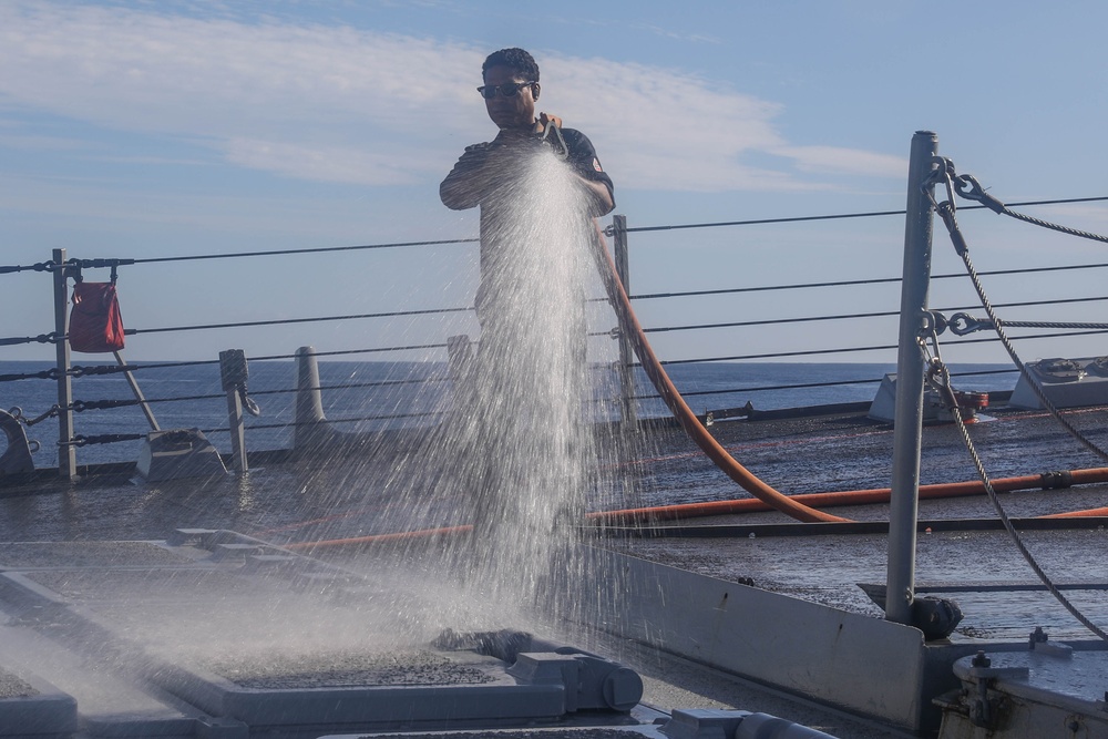 Sailors aboard the USS Rafael Peralta (DDG 115) conduct a freshwater wash down in the East China Sea