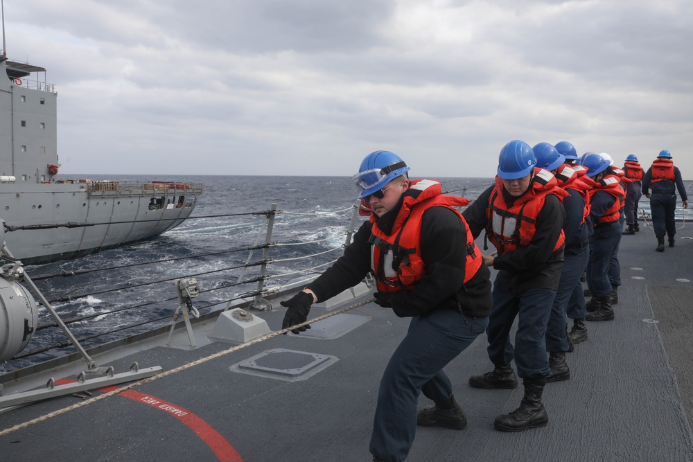 Sailors aboard the USS Rafael Peralta (DDG 115) conduct a replenishment-at-sea with the USNS Big Horn in the East China Sea