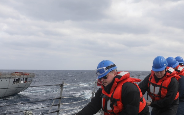 Sailors aboard the USS Rafael Peralta (DDG 115) conduct a replenishment-at-sea with the USNS Big Horn in the East China Sea