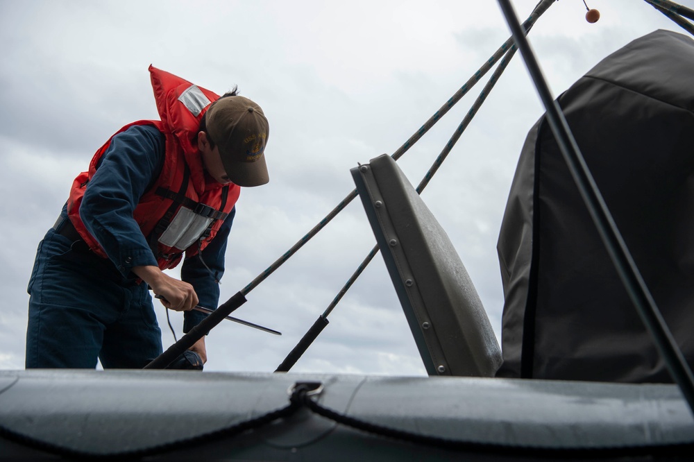 USS Kidd (DDG 100) Sailor Performs Small Boat Maintenance