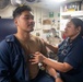 HM2 Gonzalez listens to the heart rate of GM2 Almeida aboard USS Antietam (CG 54)