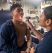 HM2 Gonzalez inspects the throat of GM2 Almeida aboard USS Antietam (CG 54)