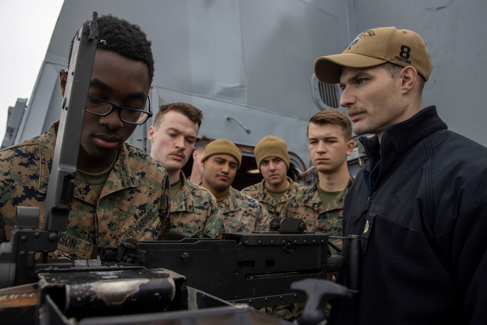 Marines familiarize themselves with machine guns aboard the USS New York