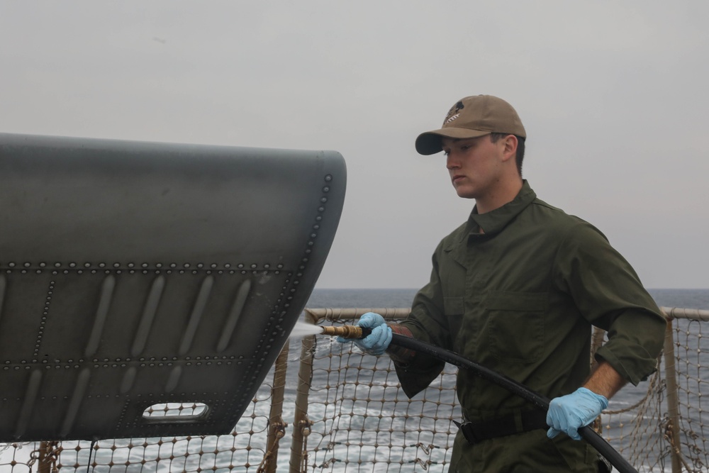 Sailors aboard the USS Rafael Peralta (DDG 115) clean a Seahawk helicopter (MH-60R) in the Sea of Japan