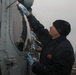 Sailors aboard the USS Rafael Peralta (DDG 115) clean a Seahawk helicopter (MH-60R) in the Sea of Japan