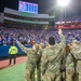 Soldiers wave at a crowd during an NFL Game
