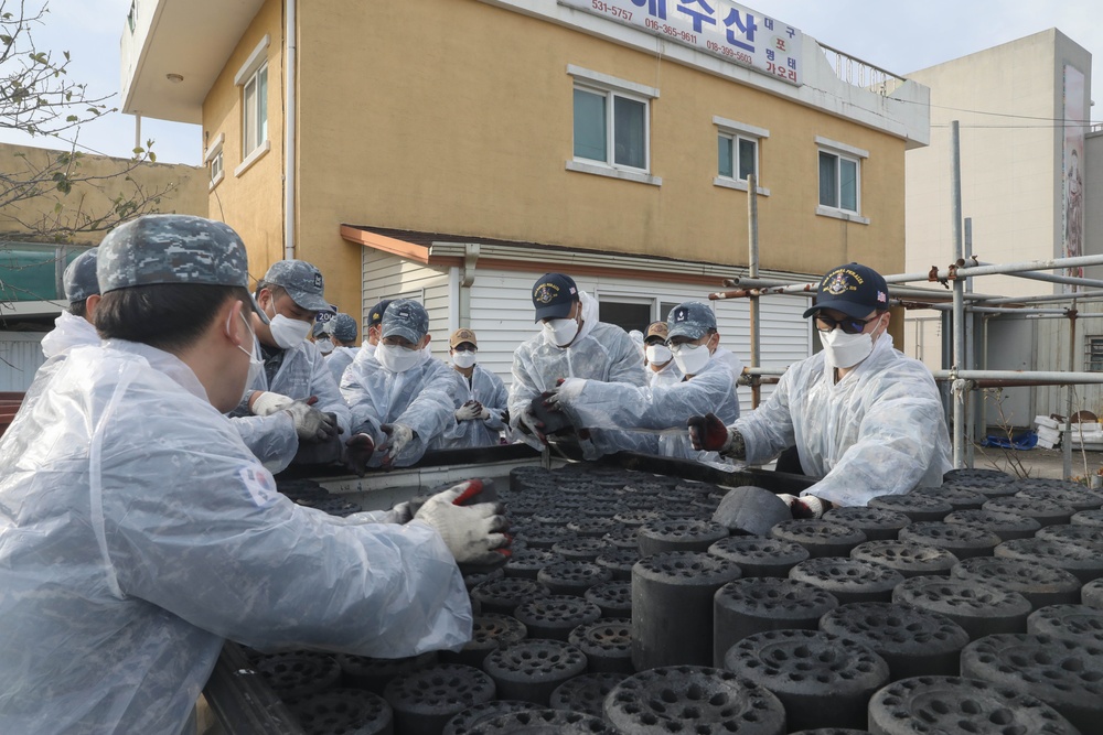 Sailors assigned to the USS Rafael Peralta (DDG 115) work with sailors assigned to the Republic of Korea Navy Daegu-class frigate ROKS Pohang (FFG-825) and the Korean government to provide coal to local houses in Donghae, Republic of Korea