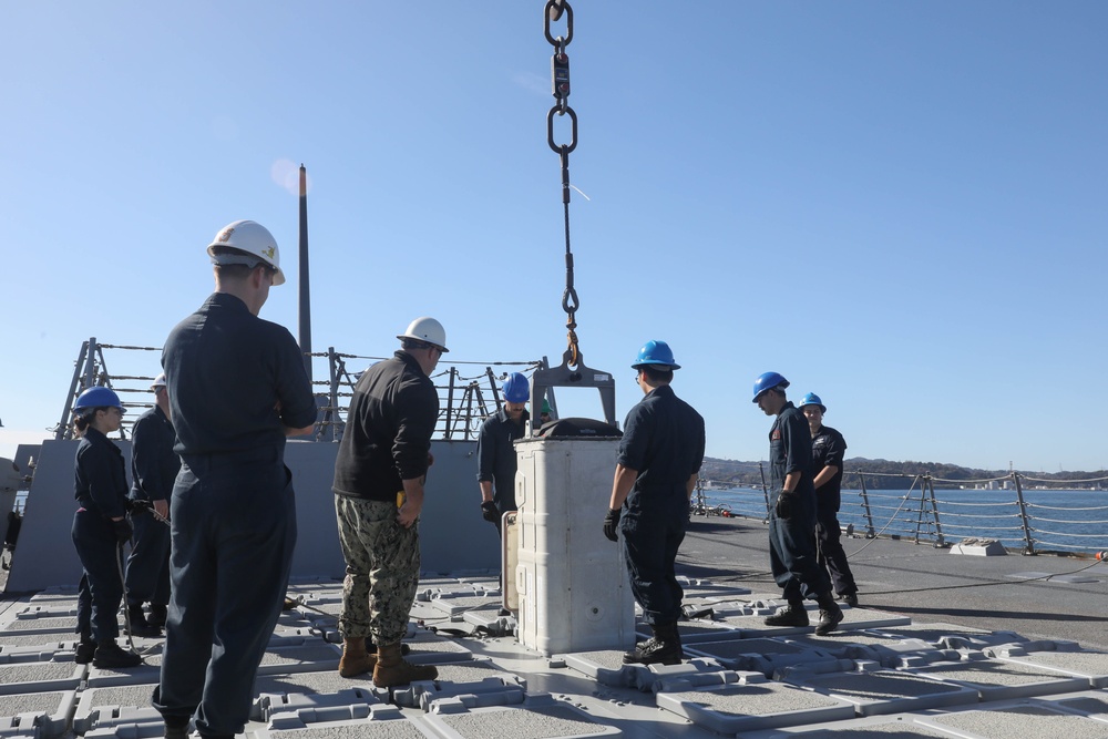 Sailors aboard the USS Rafael Peralta (DDG 115) conduct a missile offload in Yokosuka, Japan