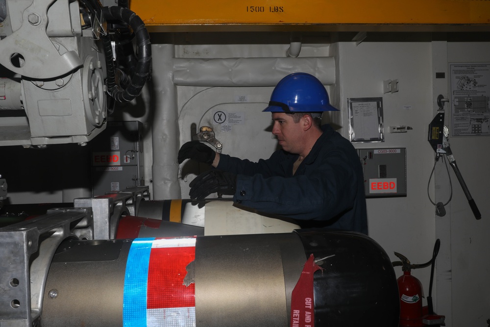 Sailors aboard the USS Rafael Peralta (DDG 115) conduct a torpedo handling event