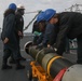 Sailors aboard the USS Rafael Peralta (DDG 115) conduct a torpedo download on the aft missile deck in the Sea of Japan