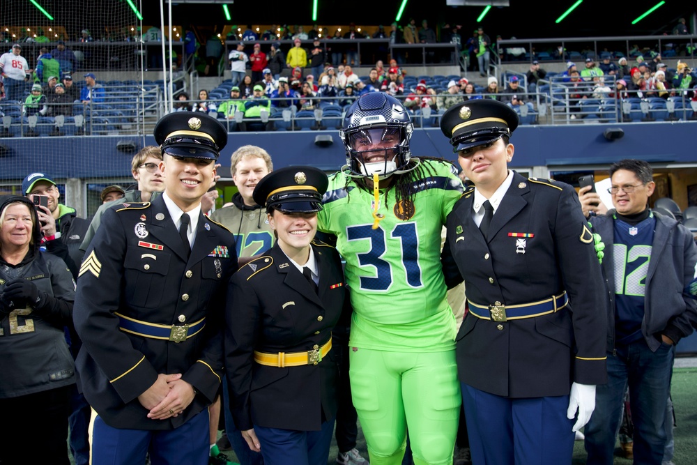 Washington National Guard service members service color guard during Thanksgiving game at Lumen Field