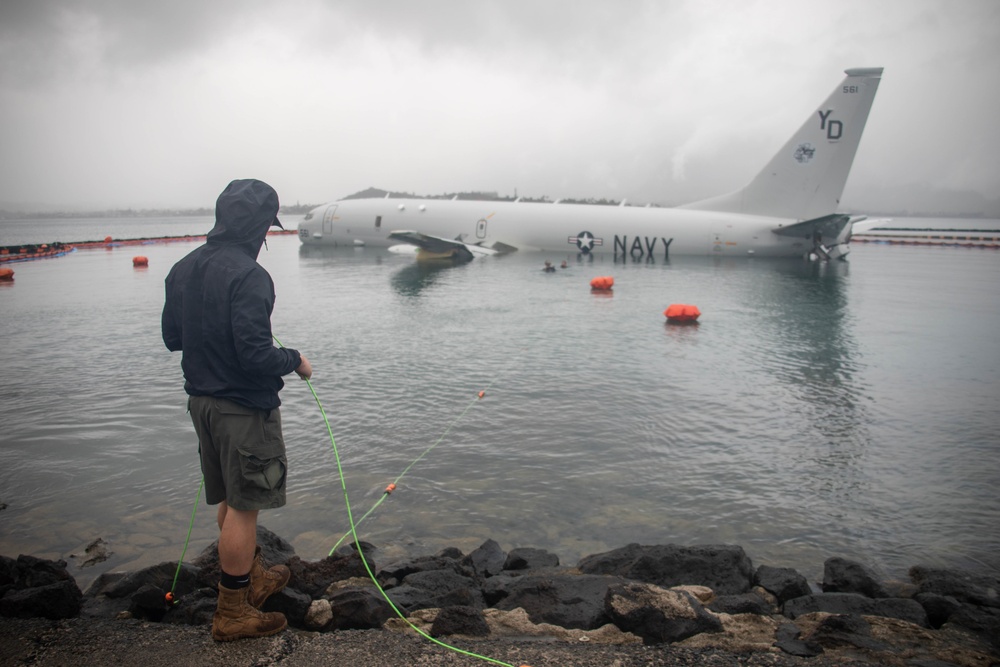 Experts prepare a U.S. Navy P-8A Poseidon in Kaneohe Bay for Salvage Operations