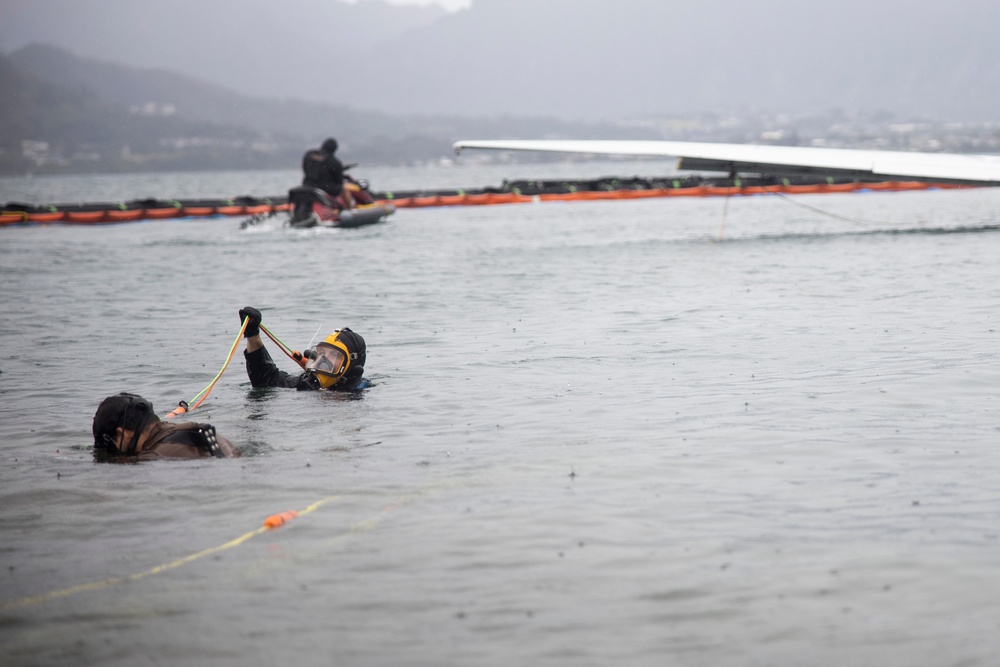 Experts prepare a U.S. Navy P-8A Poseidon in Kaneohe Bay for Salvage Operations