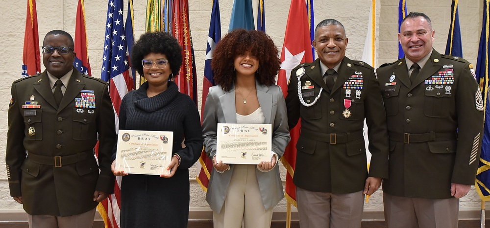 Daughters of Sgt. Maj. Felix Lassus display BRAT certificates during their father's retirement ceremony