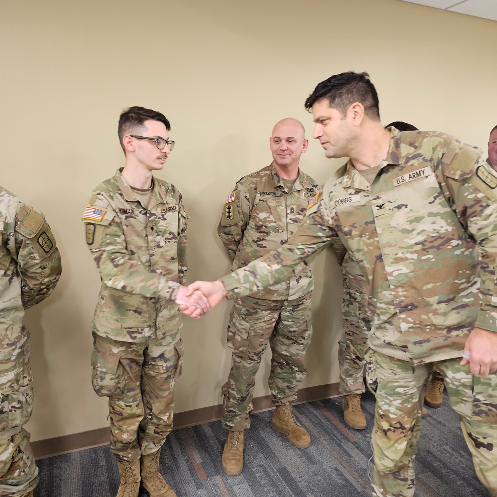 Spc. Christopher Homan receives a Commander's Coin of Excellence