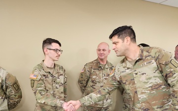 Spc. Christopher Homan receives a Commander's Coin of Excellence