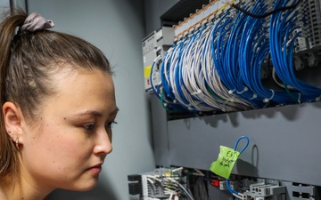 NSWC IHD engineer performs field wiring on a shipboard programmable logic controller