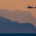 A MH-60 Helicopter flies over Mountains in the Strait of Hormuz