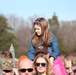 Children watch on parents shoulders during Wreaths Across America event at Yorktown National Cemetery