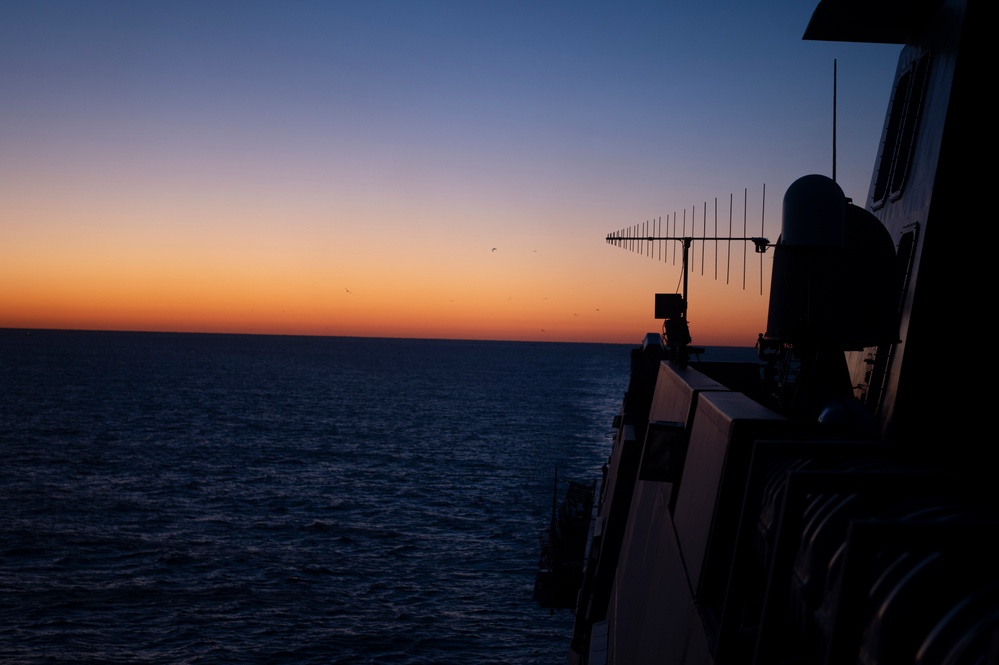 The Sun rises in the wake of USS New York (LPD-21)