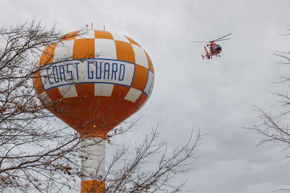 Coast Guard helicopter maneuvers around water tower