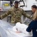 Many hands make light work: Deployed Airmen train to assist mortuary specialists with a full body wrap