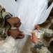 Many hands make light work: Deployed Airmen train to assist mortuary specialists with a full body wrap