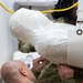 Many hands make light work: Deployed Airmen train to assist mortuary specialists with a full body wrap