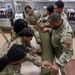 Many hands make light work: Deployed Airmen train to assist mortuary specialists with a full body wrap