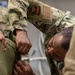 Many hands make light work: Deployed Airmen train to assist mortuary specialists with a full body wrap