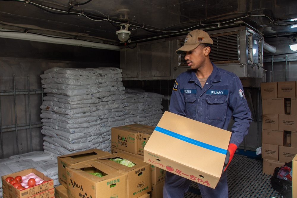 USS Ronald Reagan (CVN 76) Sailors move produce into storage