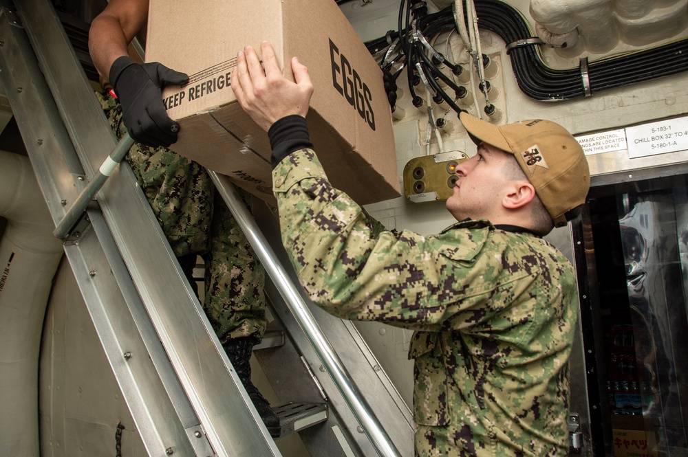 USS Ronald Reagan (CVN 76) Sailors move produce into storage