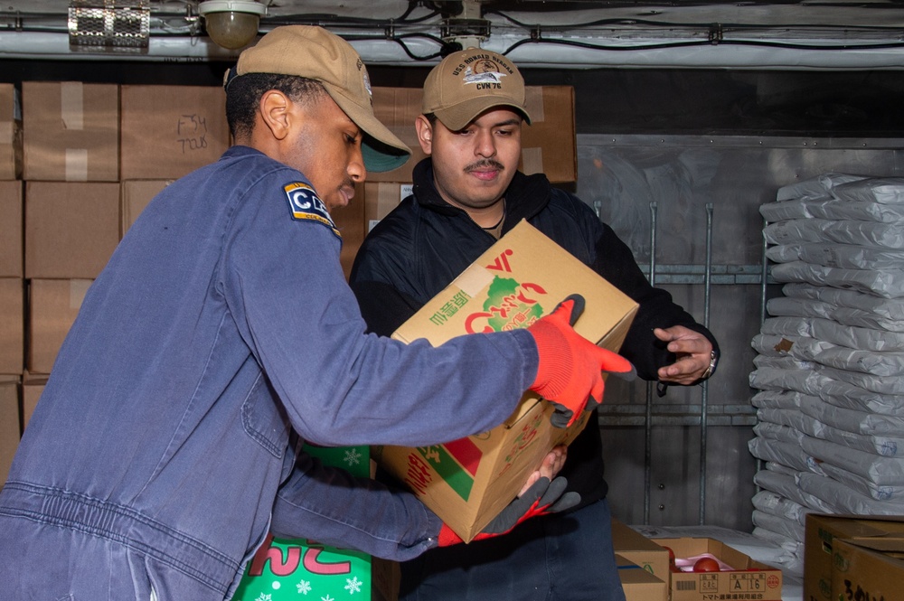 USS Ronald Reagan (CVN 76) Sailors move produce into storage