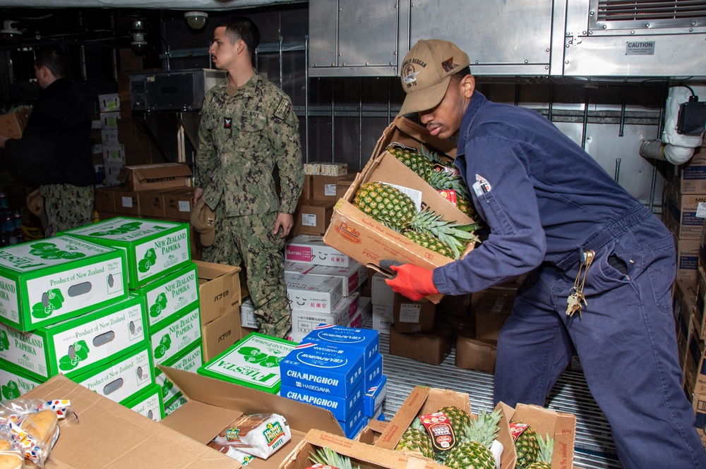 USS Ronald Reagan (CVN 76) Sailors move produce into storage