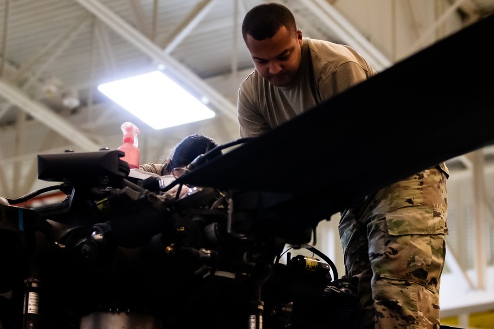 National Guard Helicopter Crew Chiefs conduct Maintenance on Black Hawk Helicopters