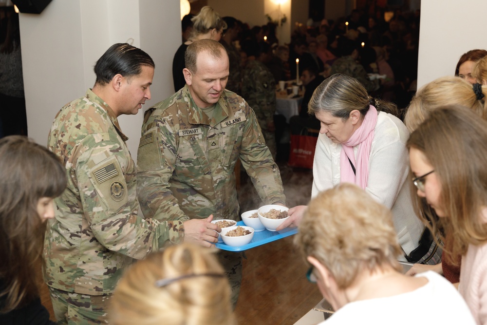 3rd Infantry Division Artillery Soldiers carol and serve food at Latvian church