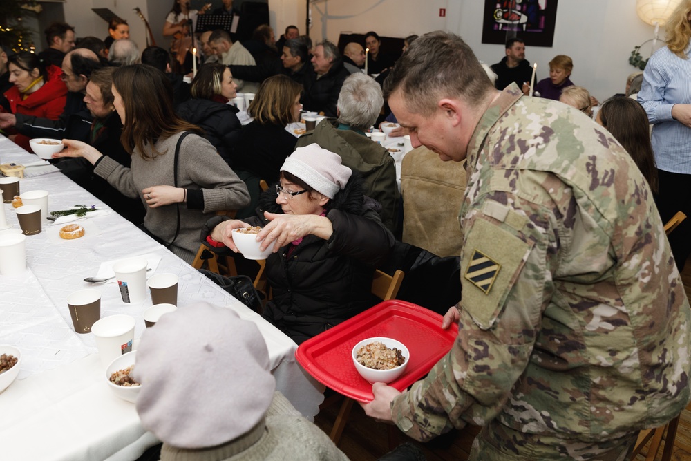 3rd Infantry Division Artillery Soldiers carol and serve food at Latvian church