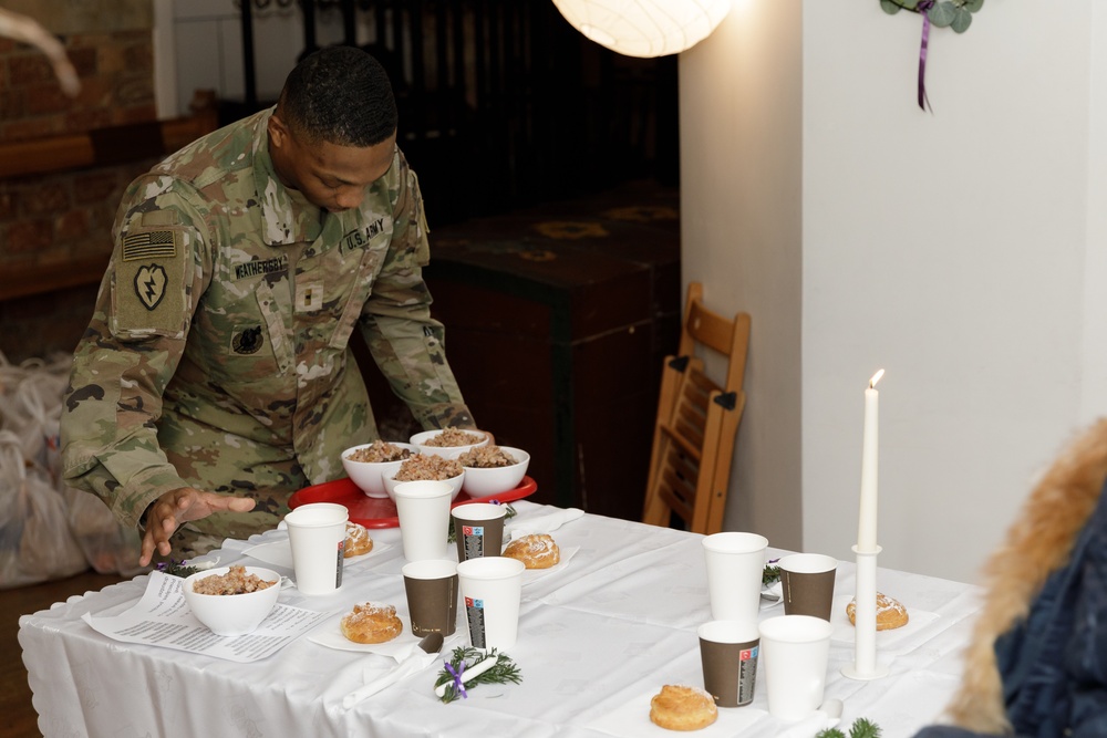 3rd Infantry Division Artillery Soldiers carol and serve food at Latvian church