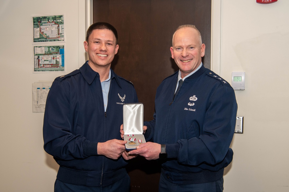 Lt. Gen. Michael Schmidt presents the defense meritorious service medal to Lt. Col. Eric Suits at the Eisenhower School