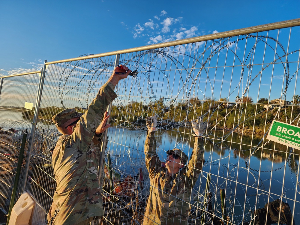 Texas National Guard Engineers install razor wire to barriers