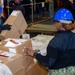 USS Ronald Reagan (CVN 76) Sailors sort supply packages for ship departments