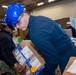 USS Ronald Reagan (CVN 76) Sailors sort supply packages for ship departments