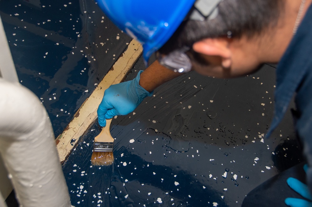 USS Ronald Reagan (CVN 76) Sailors apply clear epoxy