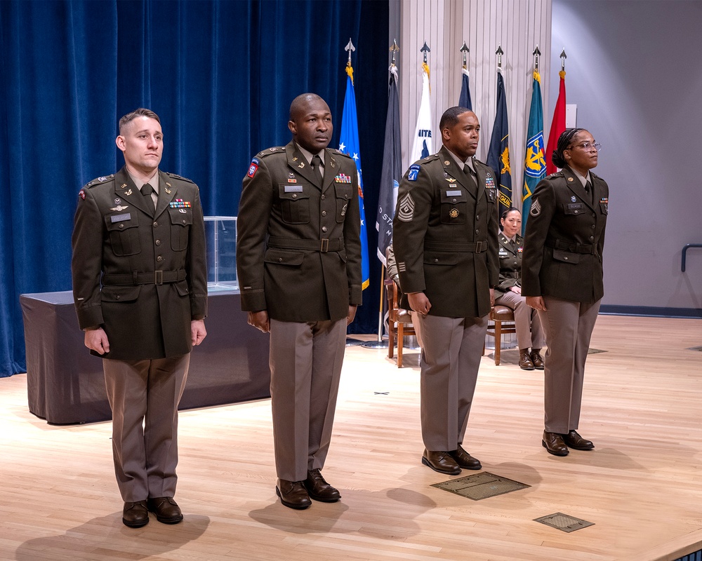 Photo By Billie Suttles | The Judge Advocate General's Legal Center and School Student Detachment Commander Capt. Keith Jaworski, Chief Warrant Officer Appolinaire Kombassere, 1st Sgt. Shamar Purdie and Staff Sgt. Monnea Slade stand at attention during the 221st Officer Basic Course graduation on December 14, 2023. (US Army photo courtesy Billie Suttles) 