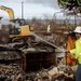 U.S. Army Corps of Engineers contractor located in the cold zone sprays water to minimize dust becoming airborne during debris removal