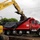 An excavator places debris in a dump truck for hauling to the Temporary Debris Storage site