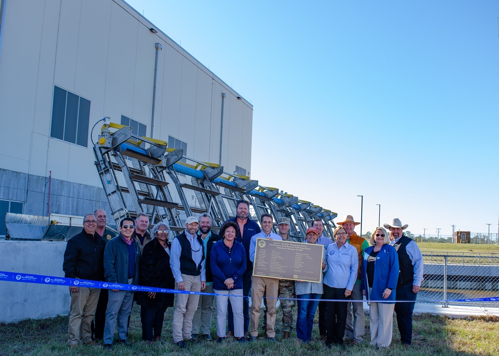 Employees of USACE, SFWMD and stakeholders hold the new plaque for the C-43 Reservoir pump station