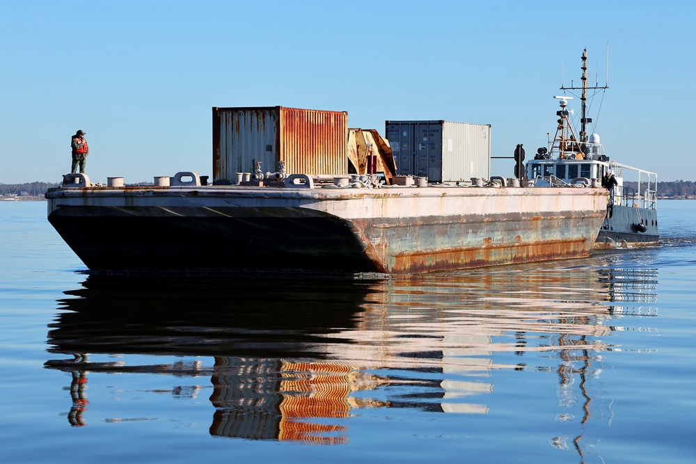 Decommissioned World War II-era fuel barge undergoing a maneuverability test to determine its towing capabilities.