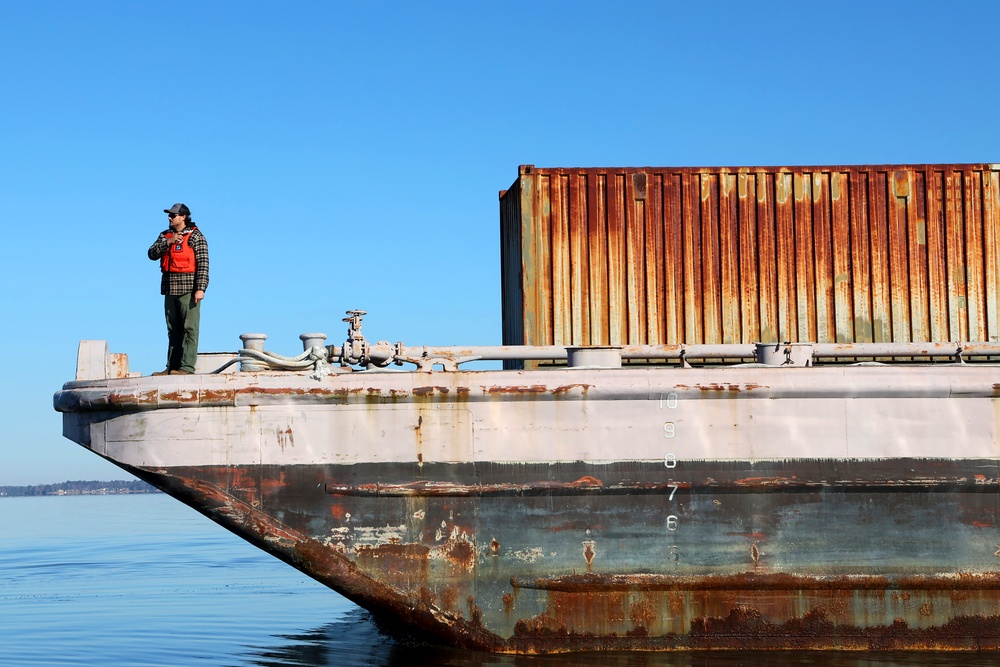 Decommissioned World War II-era fuel barge undergoing a maneuverability test to determine its towing capabilities.